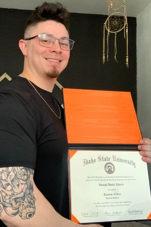 Joseph Chacon holds his ISU diploma
