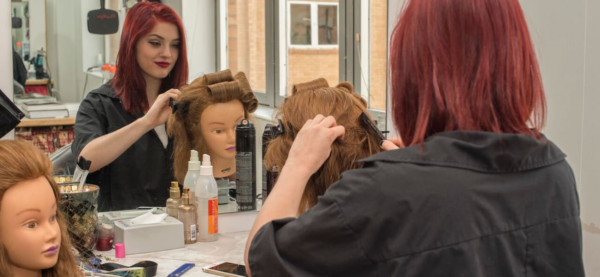 Cosmetology student practicing on a mannequin