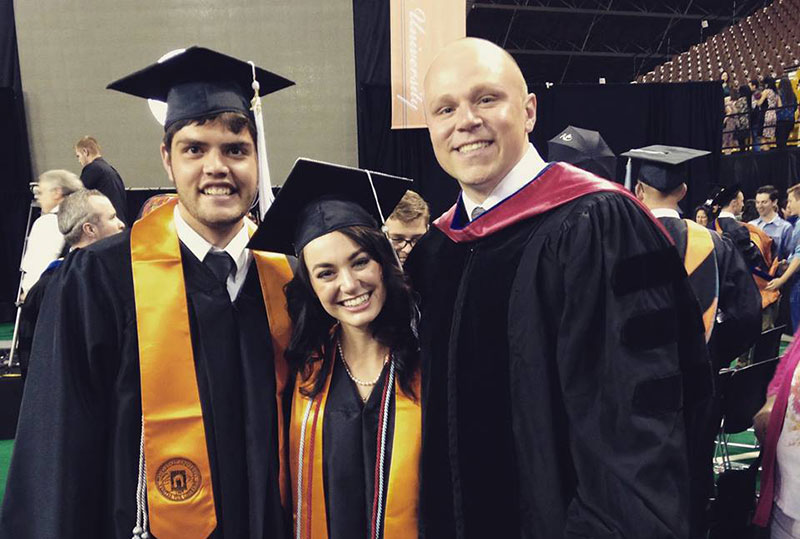 students and professor at graduation