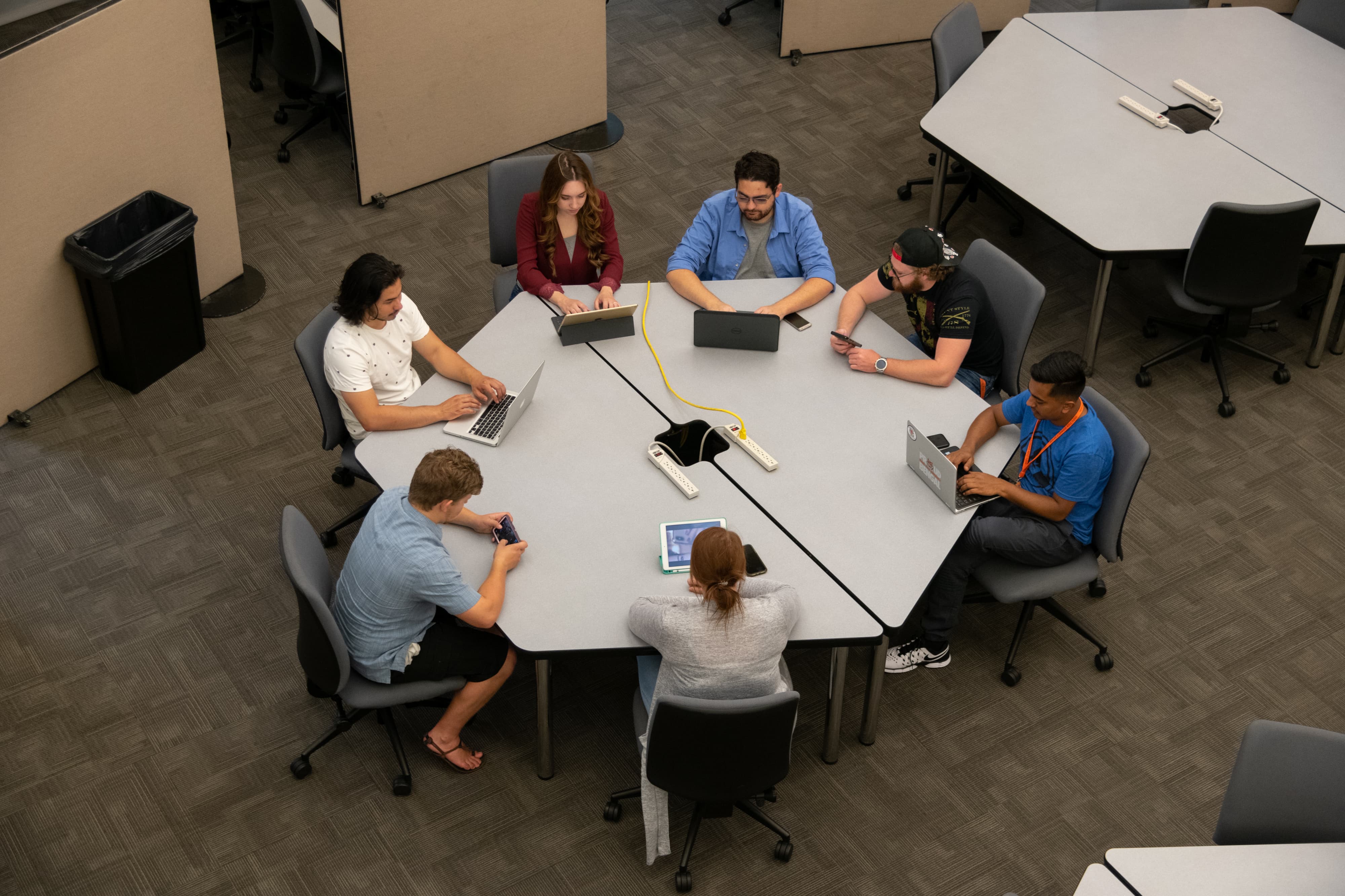 Above shot, a group of students talking around a circular table.