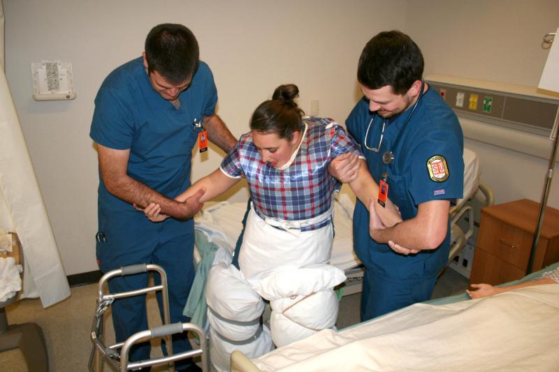 Nursing students moving patient
