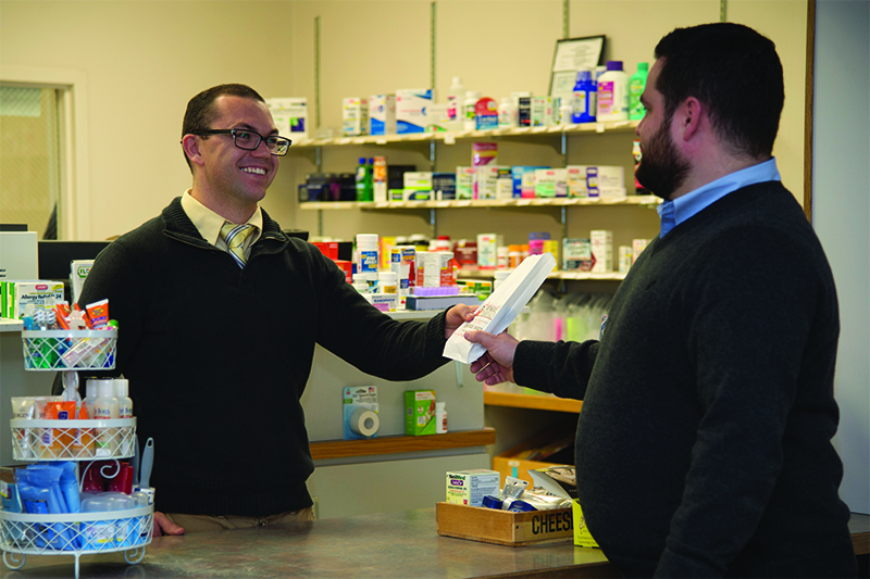 Pharmacist hands prescriptions to patient