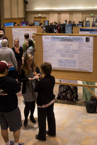 Students and faculty discussing research presentation