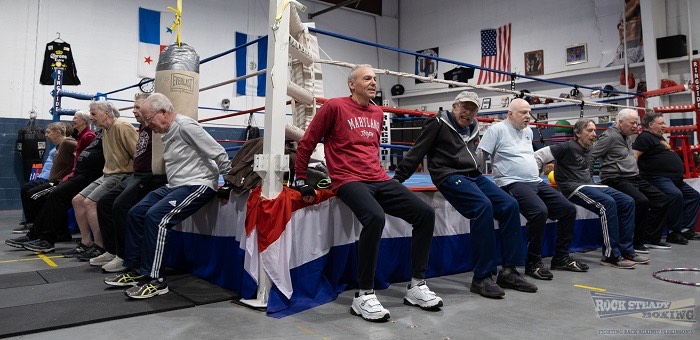elderly men stretching against a boxing ring