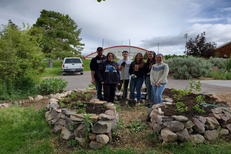 Geology Club and AmeriCorps members  posing in a community garden