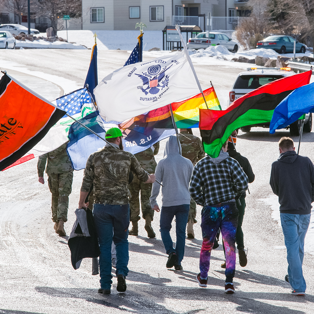 A group of students walking with several flags