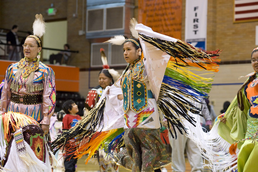 Photo of Native American female dancers in beaded, colorful costumes.