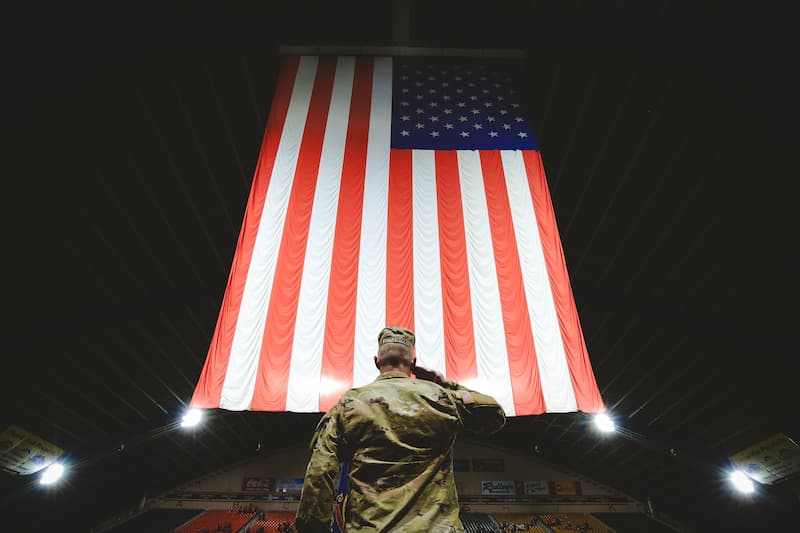 Veteran saluting the flag in Holt Arena