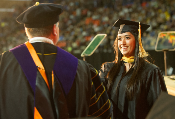 Girl accepting degree on stage at commencement