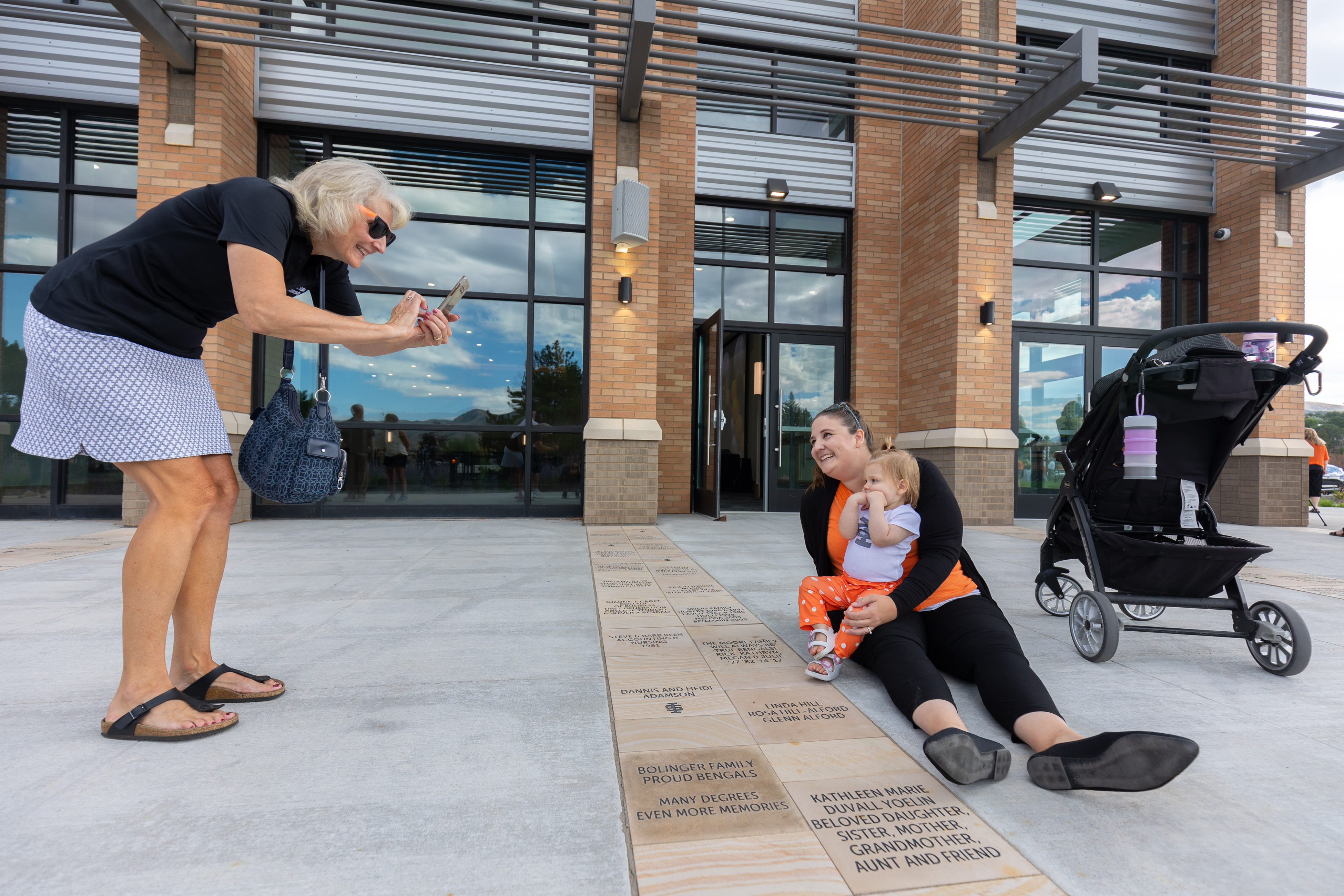 Family with posing with their paver at the Alumni Center