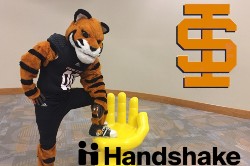 Benny Bengal leaning on the Handshake chair