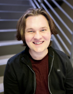 Man smiling in front of stairs