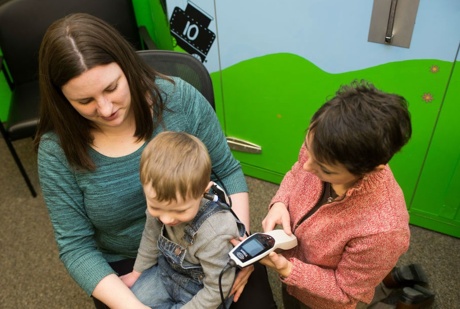 Audiologists doing a child hearing evaluation