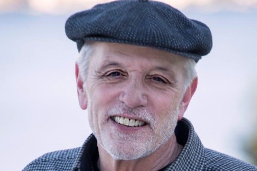 Carl A. Levenson smiling, wearing a hat outdoors in the snow