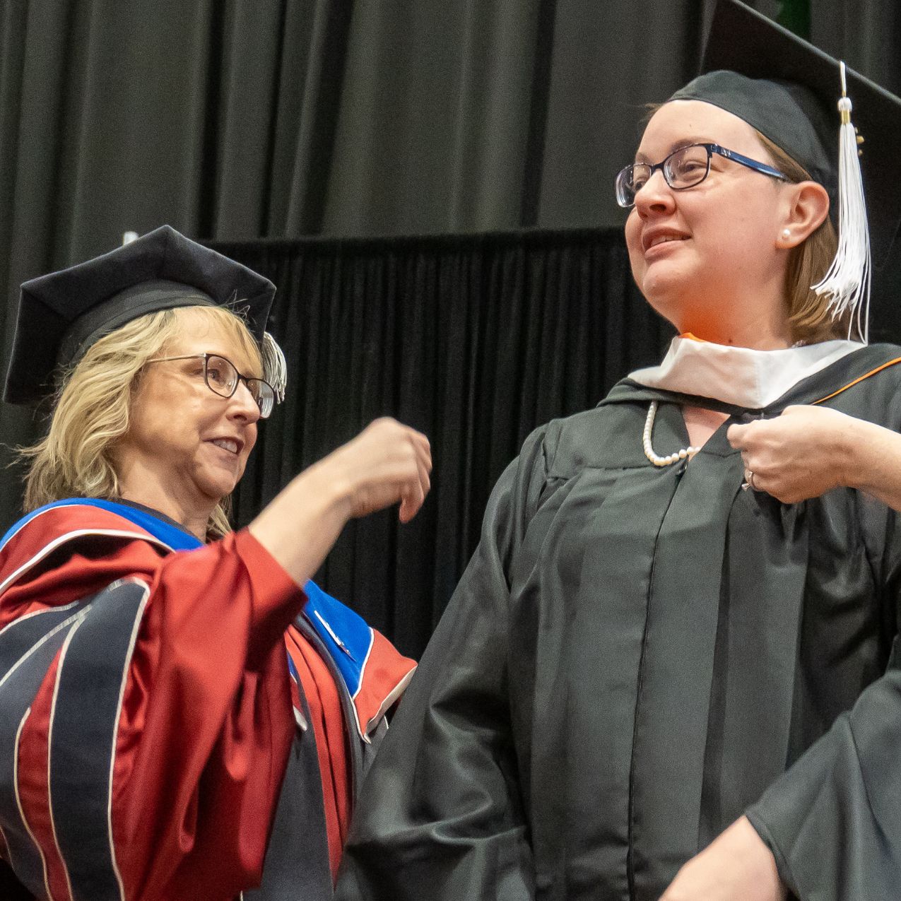 Virginia Barnett, Master of Arts in Communication recipient is hooded during commencement 2023 by Dean Kandi Turley Ames