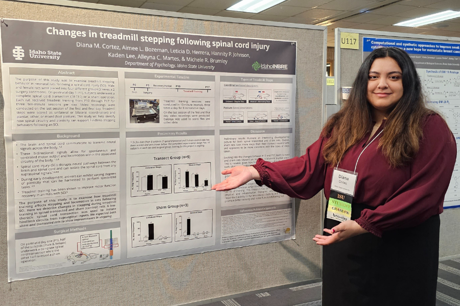 Diana Cortez stands in front of her presentation poster at the INBRE conference