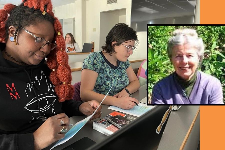 Two students sit at a desk working side by side by looking at notebooks and a laptop and writing. On the right hand side of the photo is a box frame with a headshot of Emily Boone.