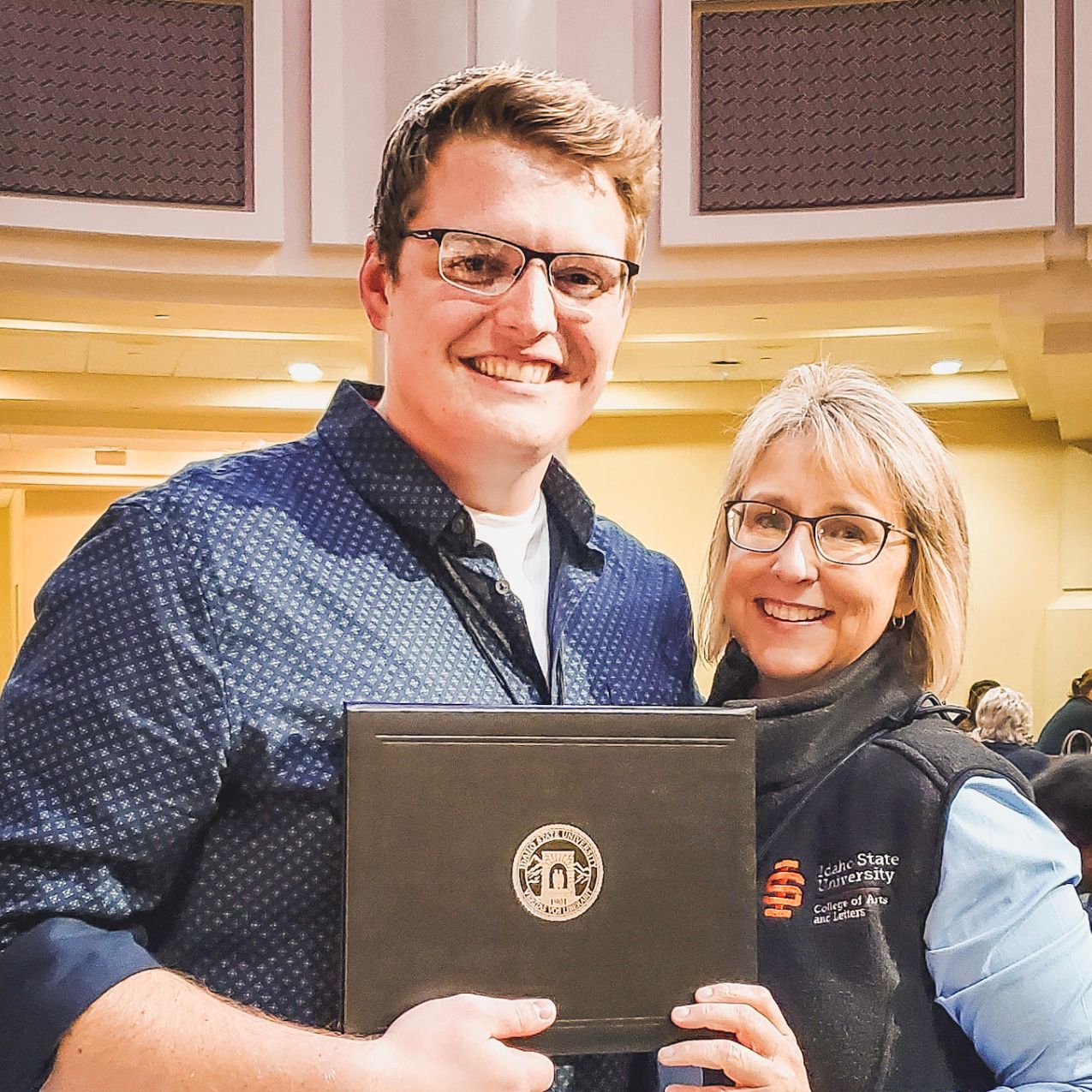 Jacob Harris, graduate student in Sociology, poses with his 3 minute thesis awards alongside the dean of the College of Arts and Letters, Kandi Turley-Ames