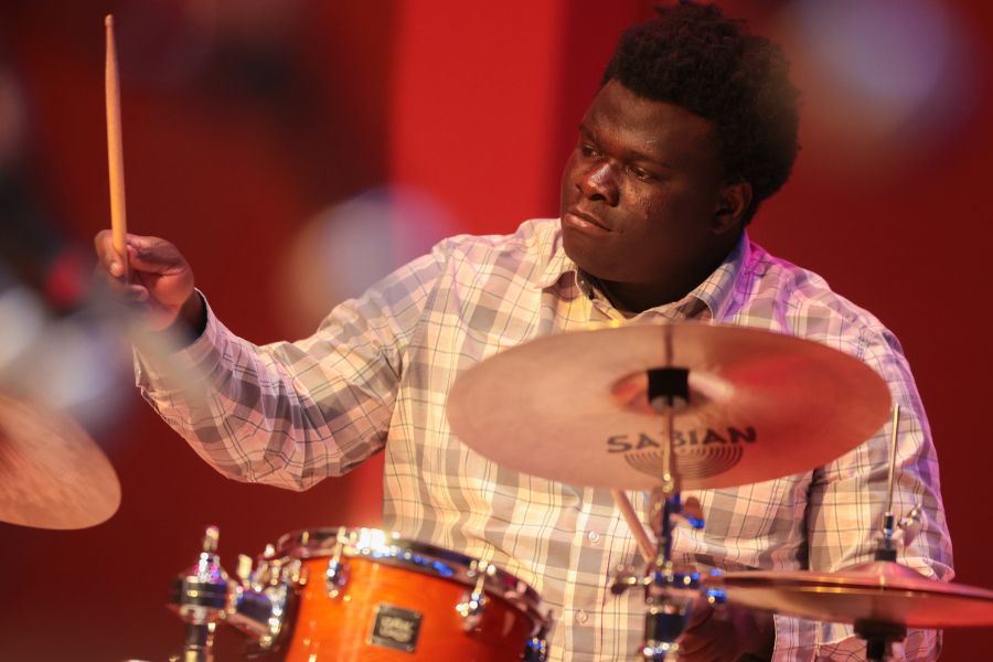 Joseph Emmanuel plays drums on the Jensen hall stage.