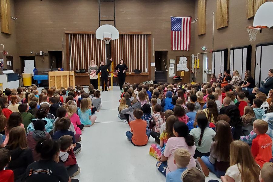 a gym full of elementary students watches ISU opera students perform