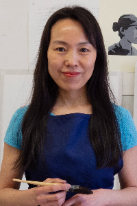 Headshot of Yidan Guo holding a paint brush