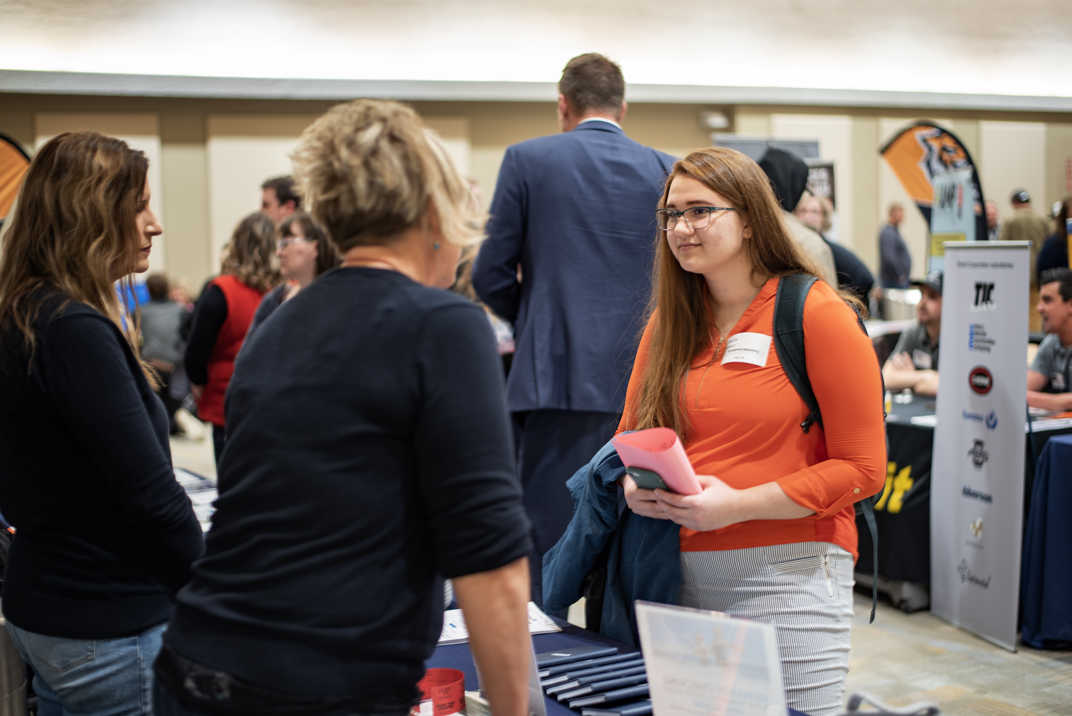 A student at a career fair talking to employers at a booth