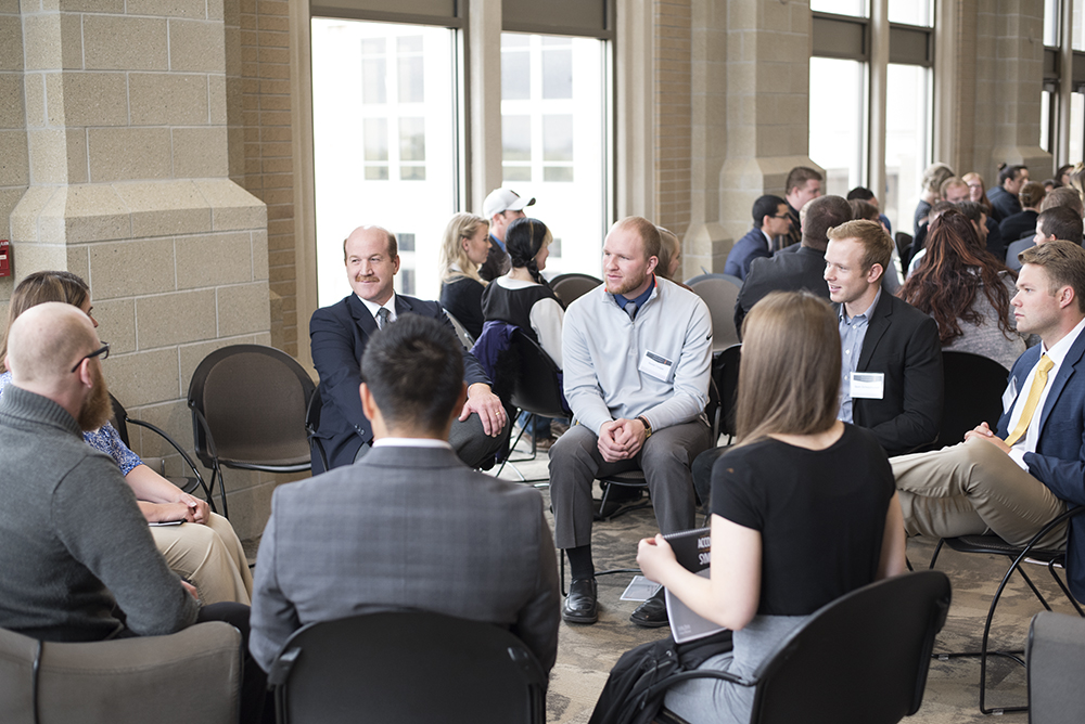 Students in professional dress sitting in a circle