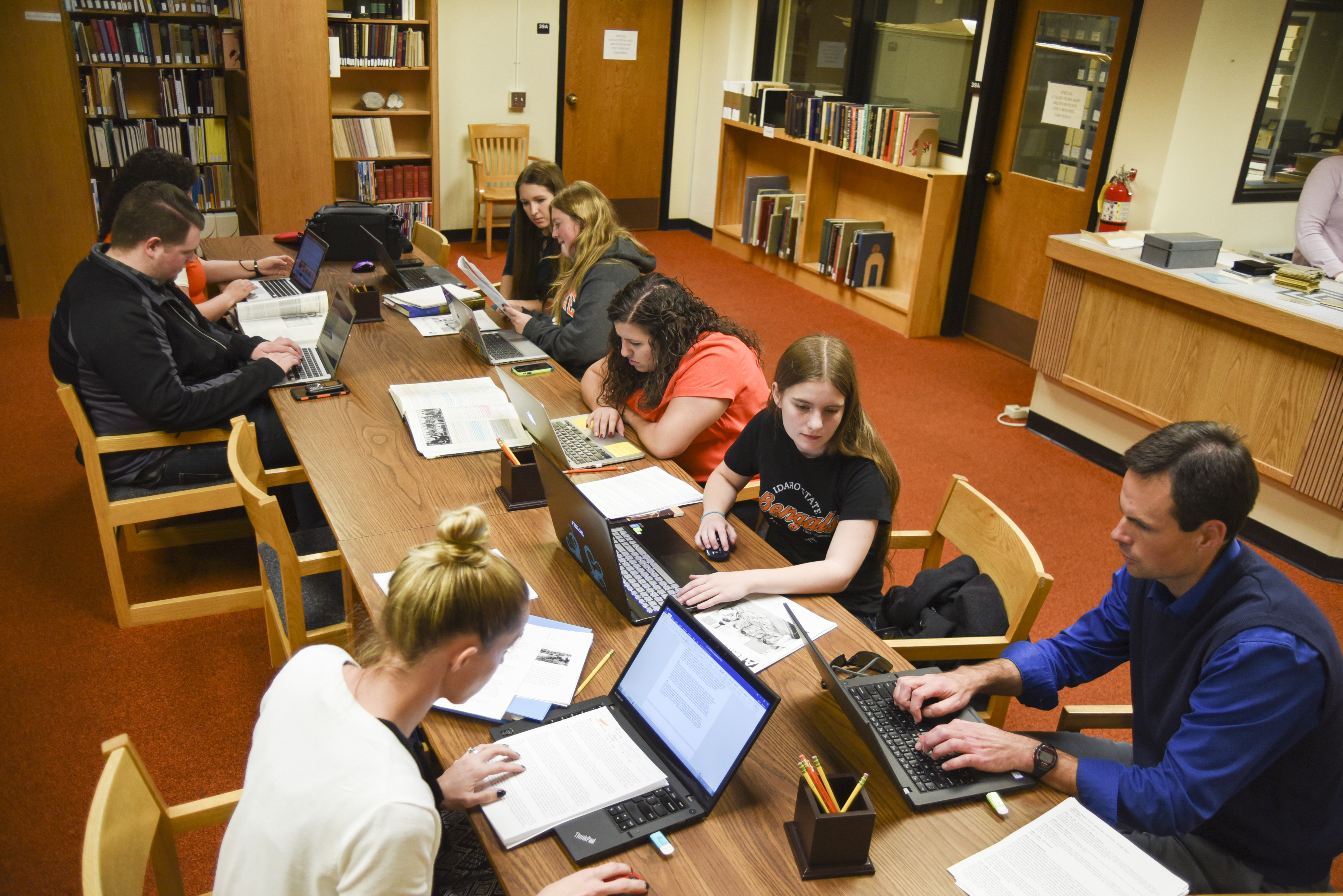 Photo of students working in a group at a long table in the library
