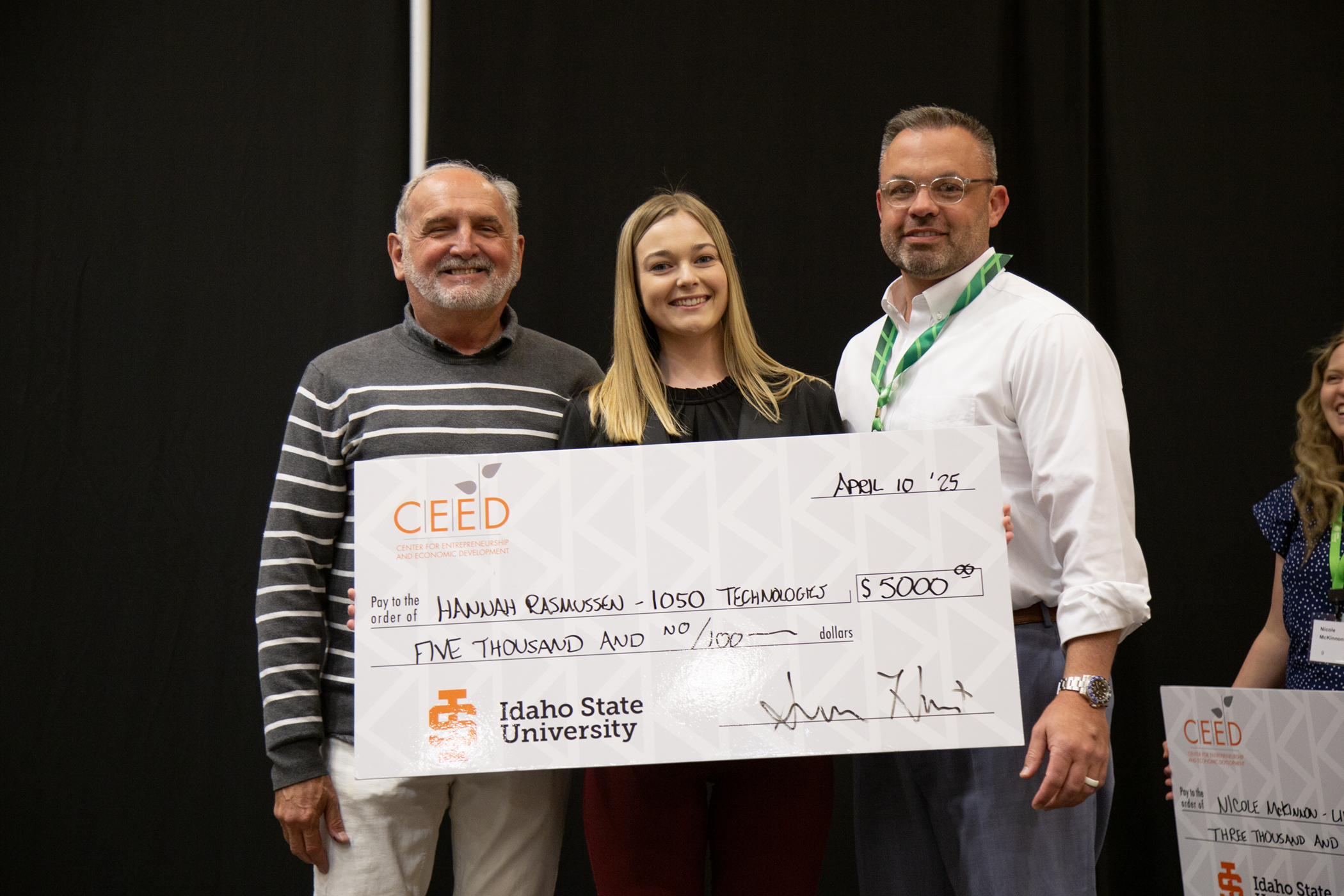 Hannah Rasmussen Receiving her first place check at the 2025 Women's Business Symposium