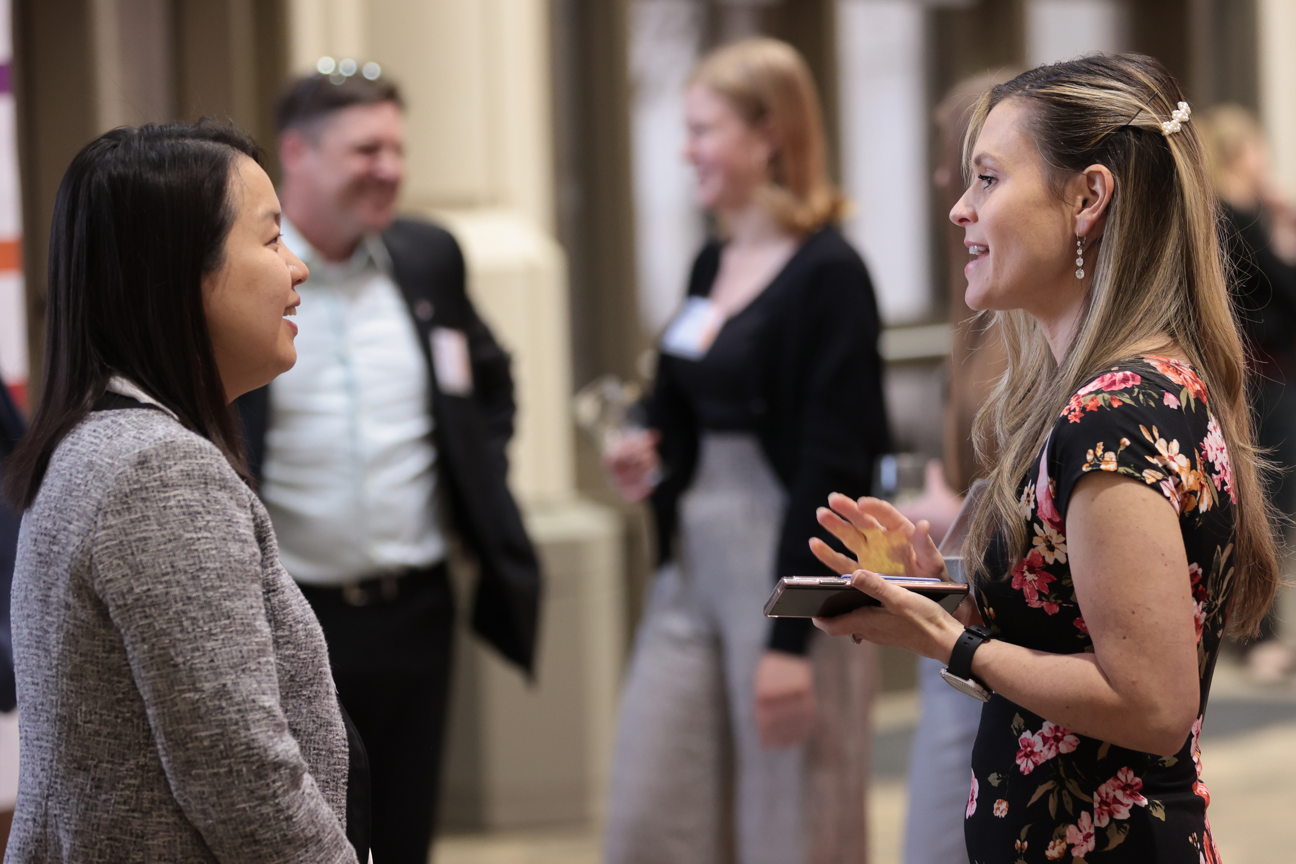 Two female students talking to each other at a professional event.