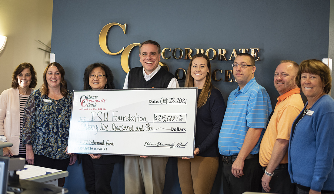 The dean holding a check with donors