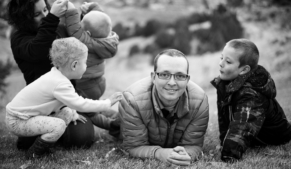 Student sitting on the ground with his family