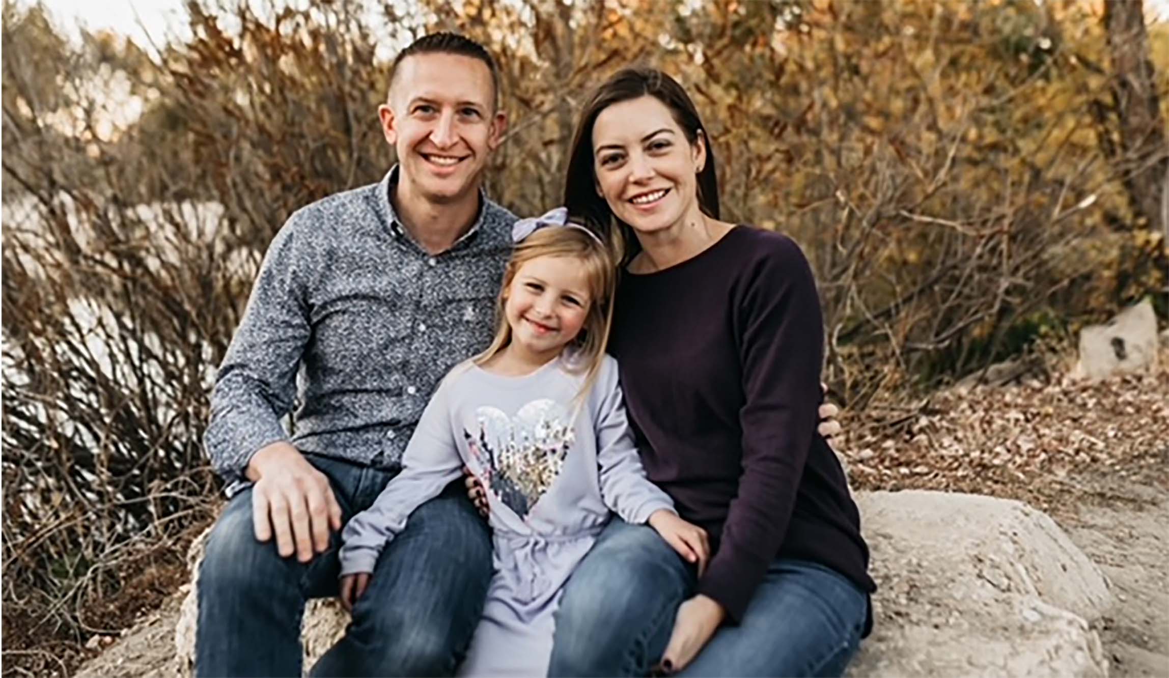 A family sitting on a rock