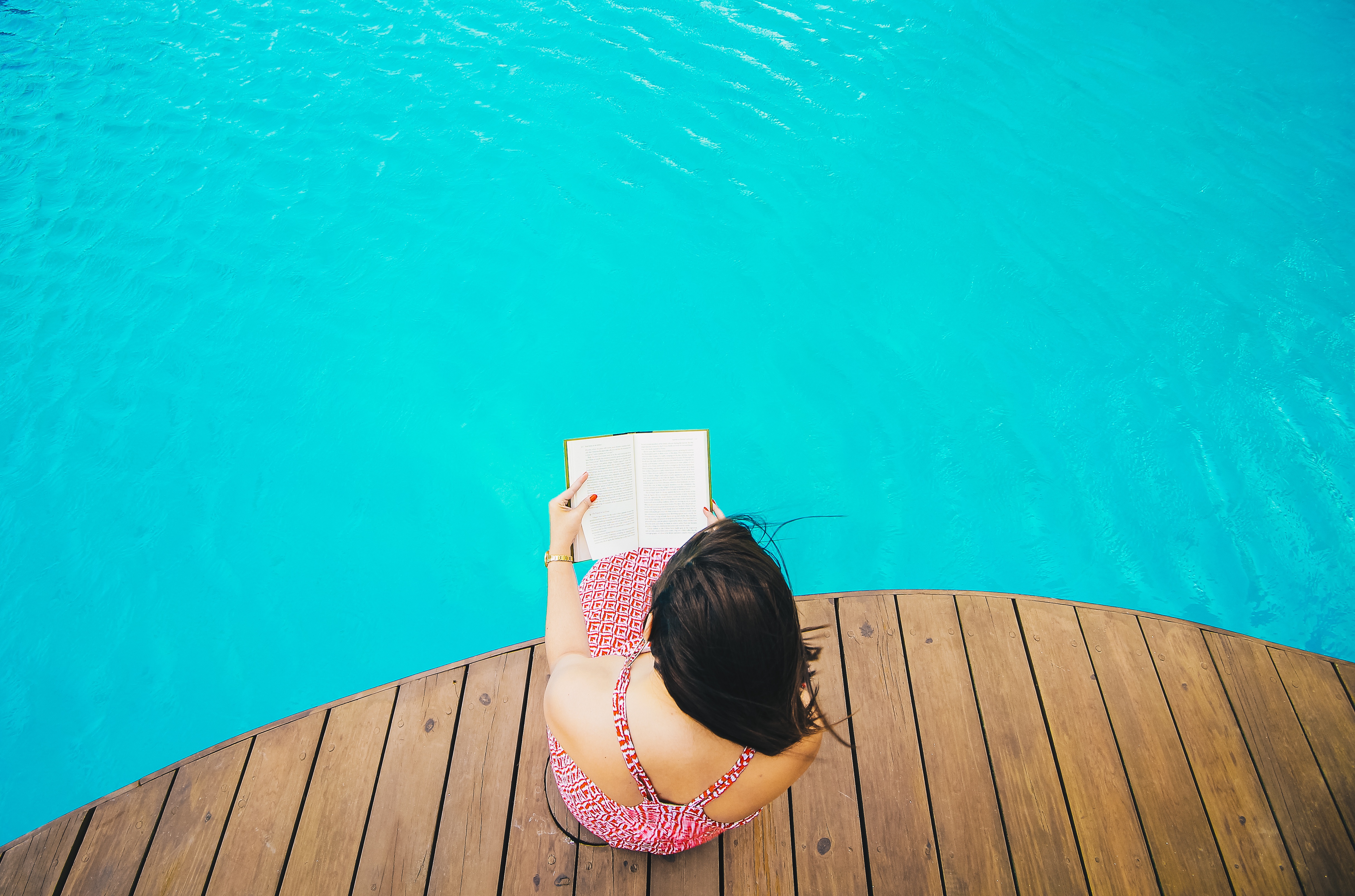 A person reading a book in the pool