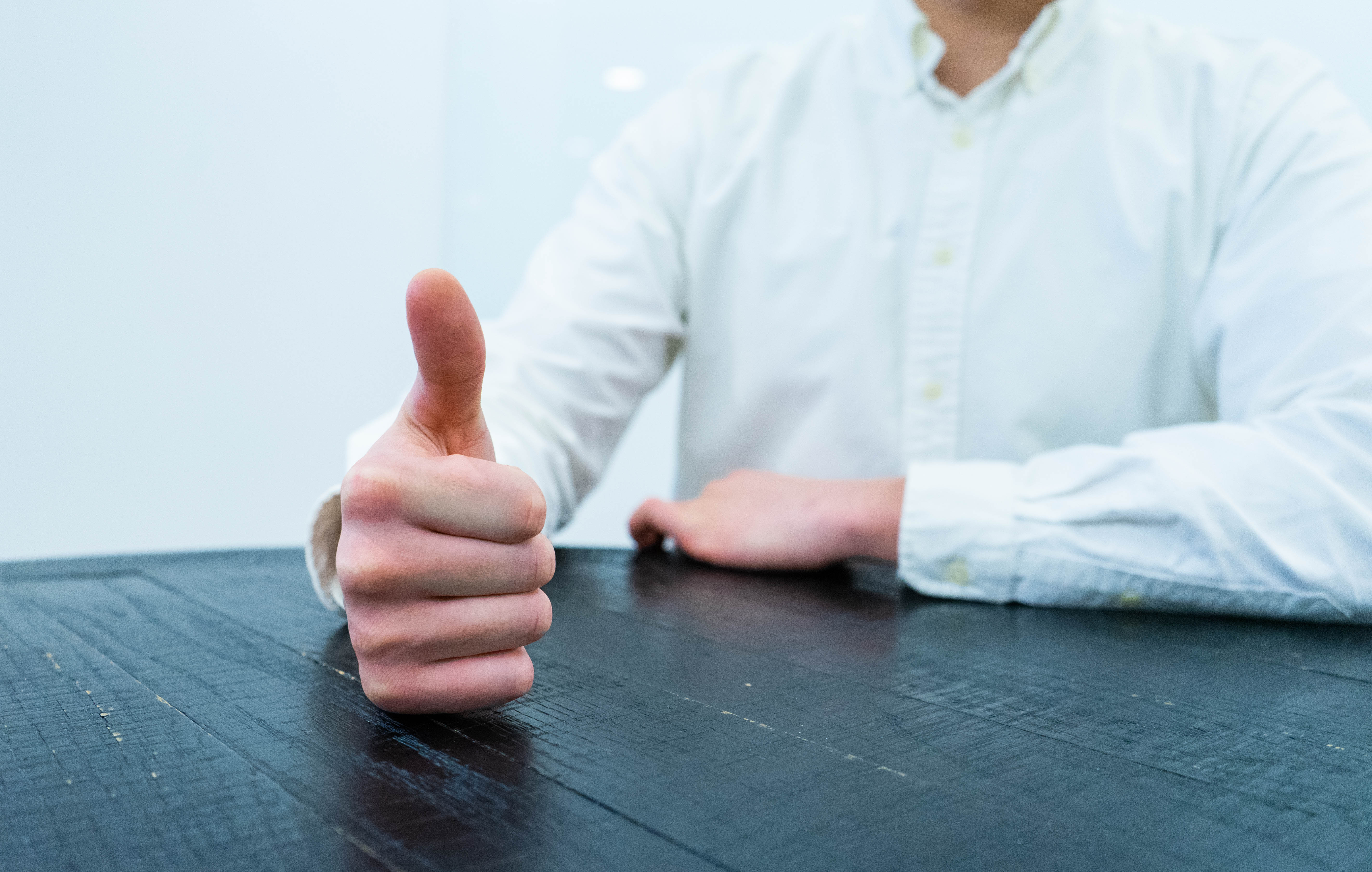 Person sitting with a thumbs up