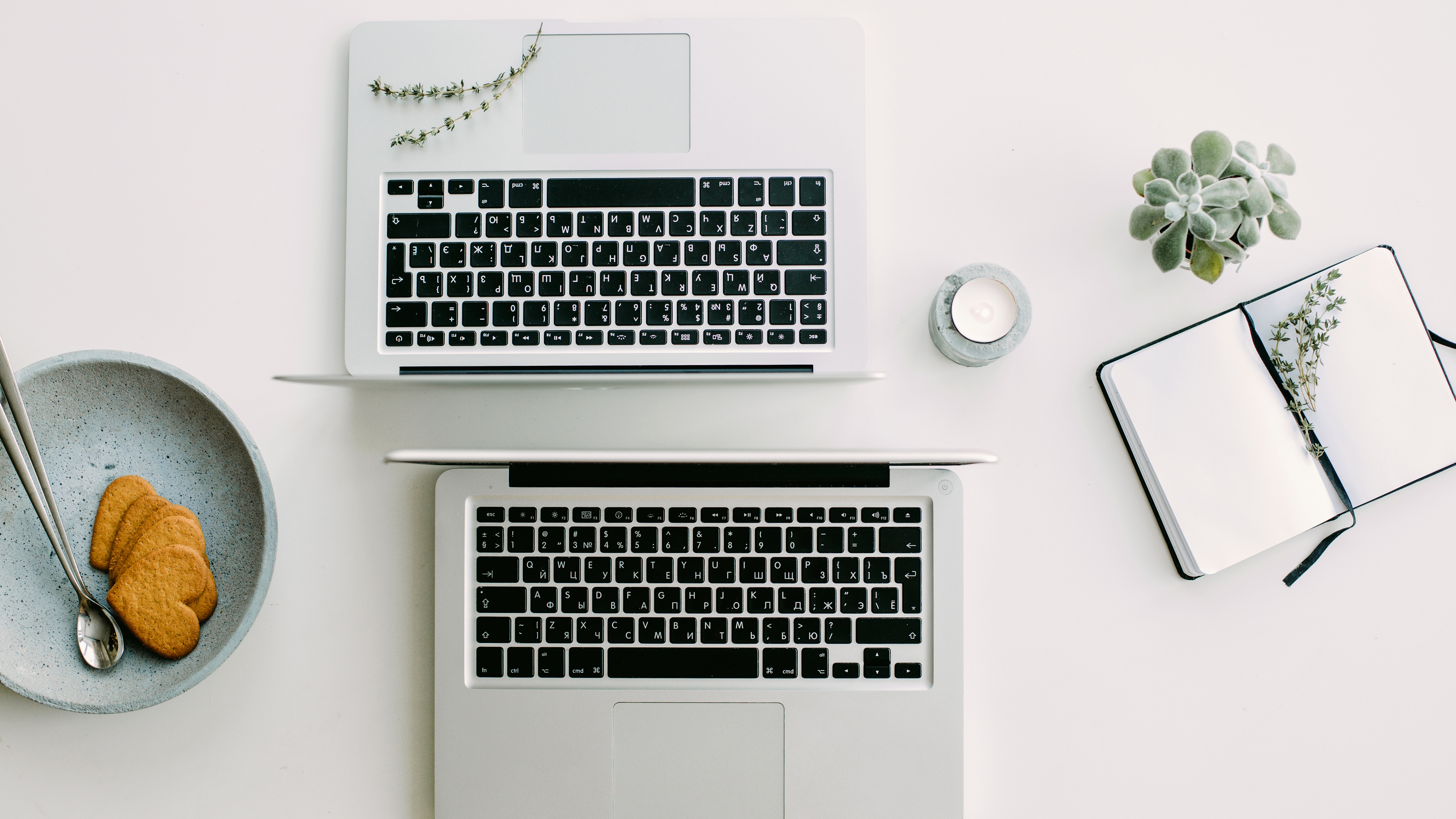 Two laptops on a desk with study materials