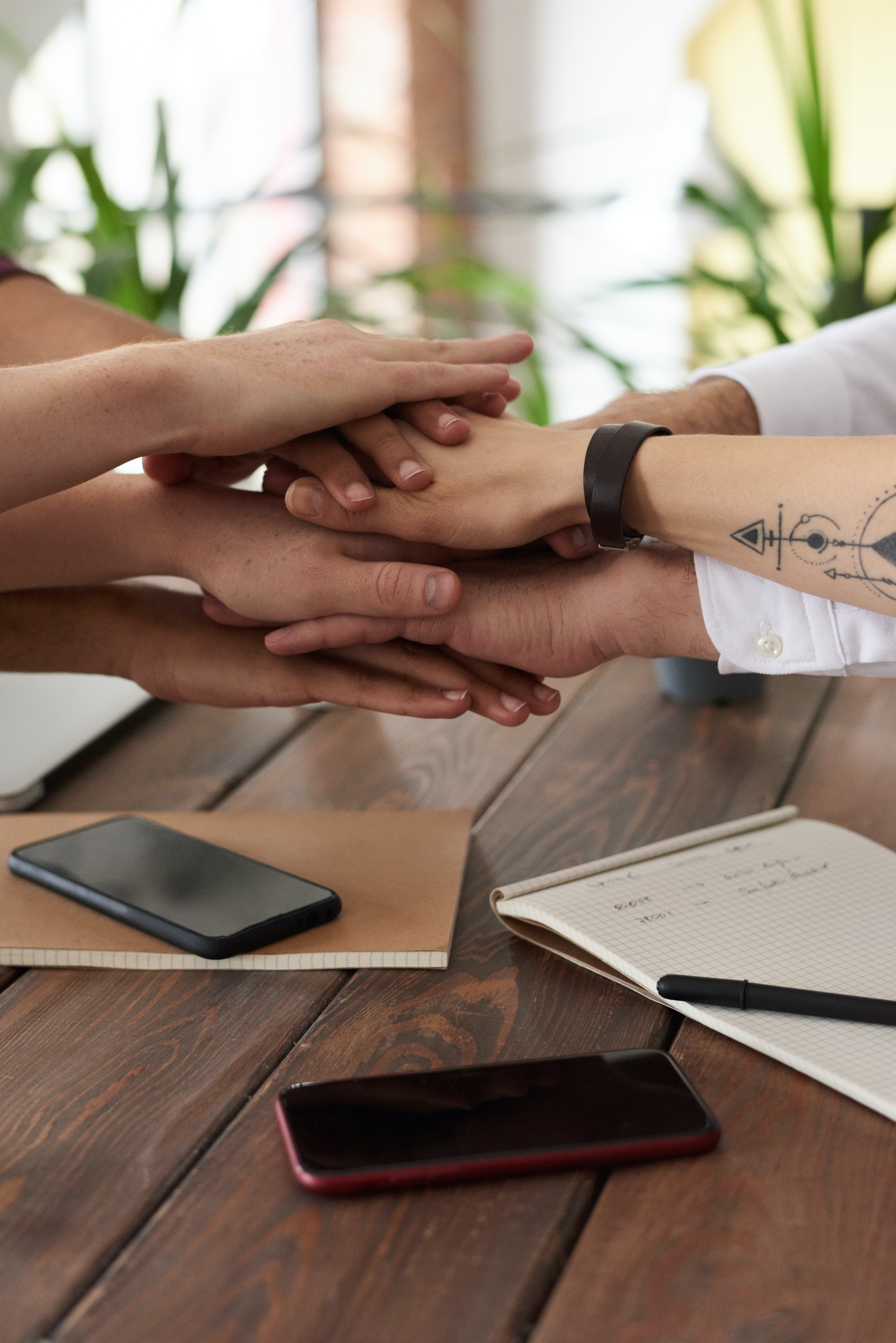 Students shaking hands over a table of homework