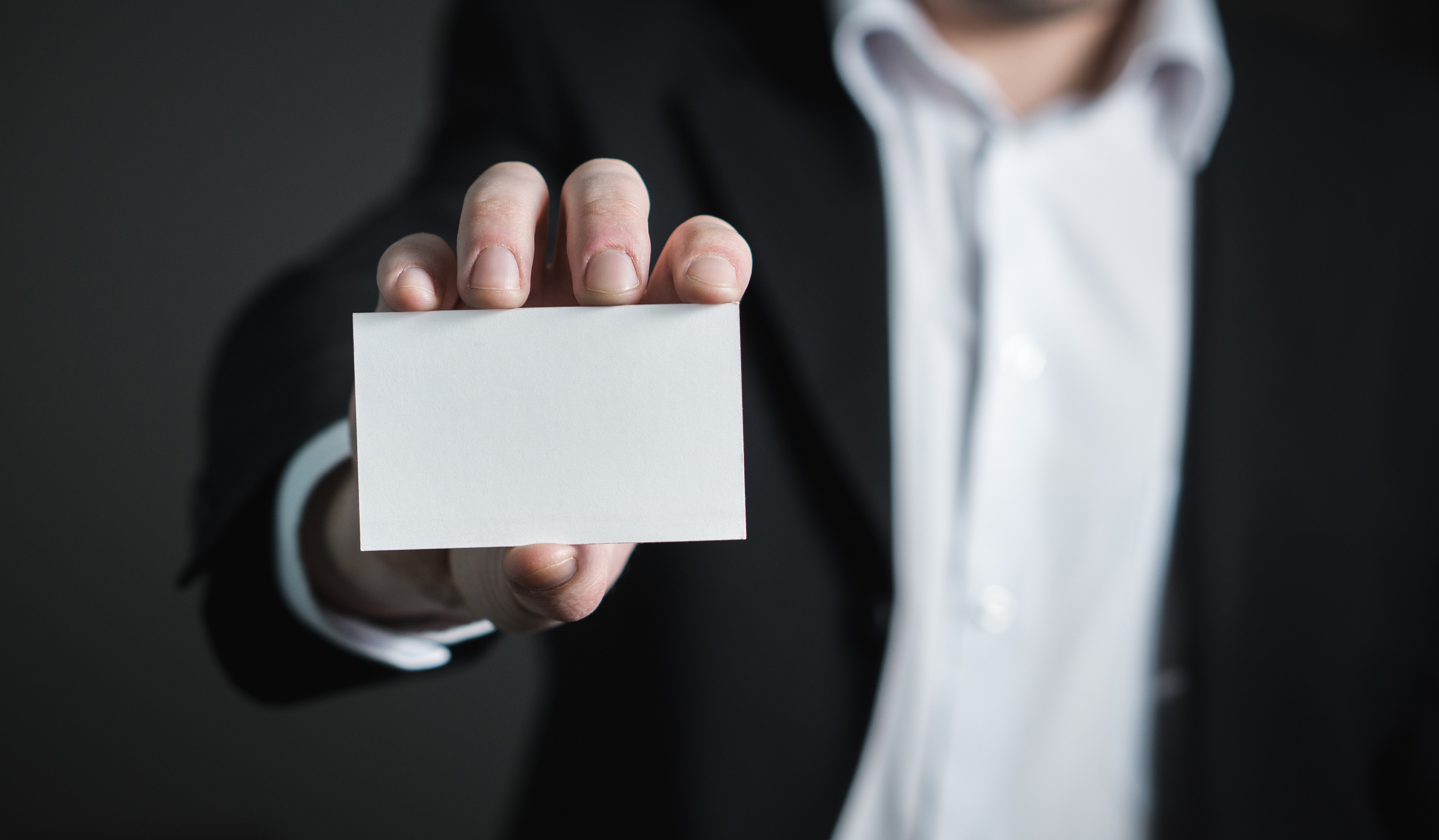 Man holding up a blank business card