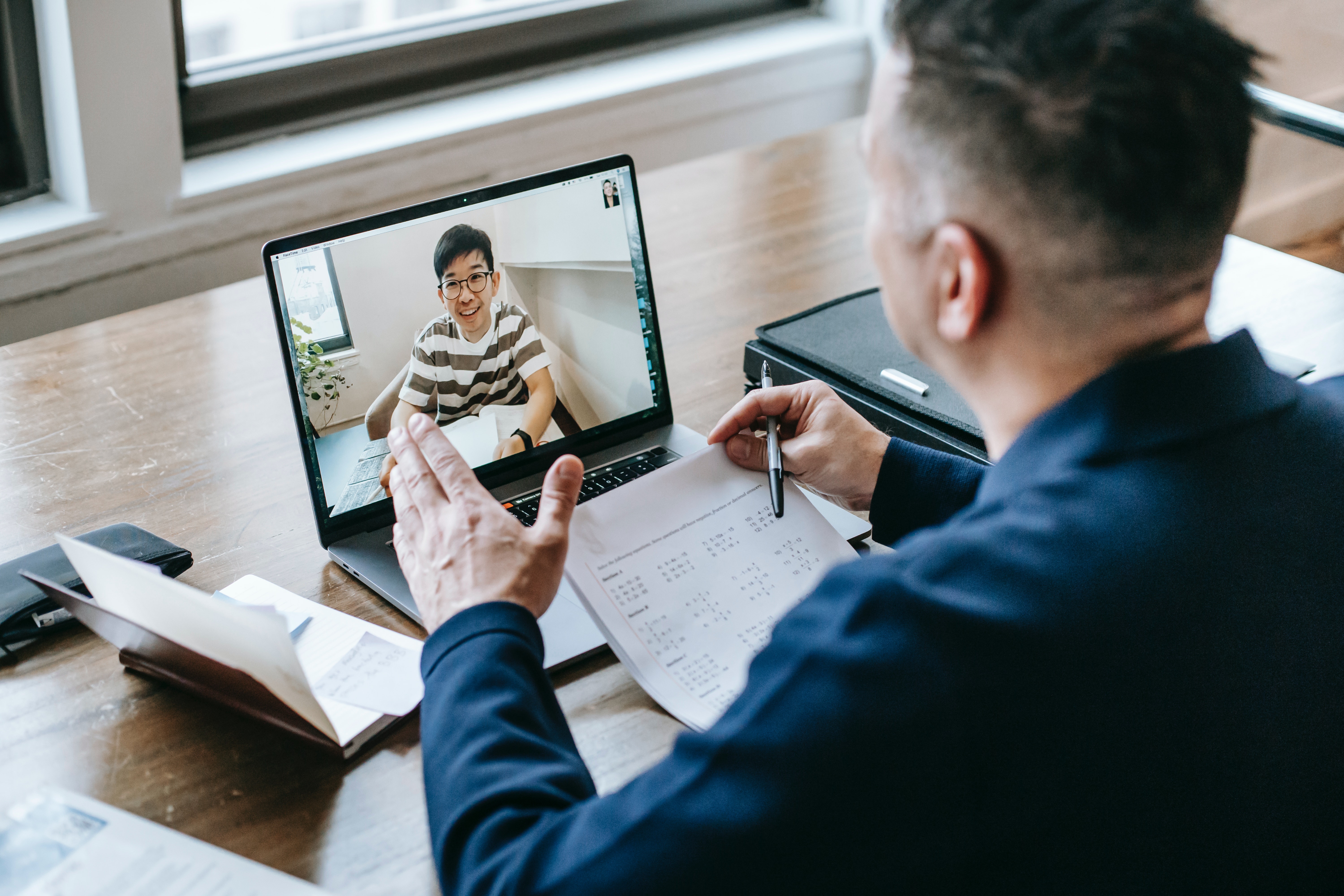 Two people video chatting over a laptop