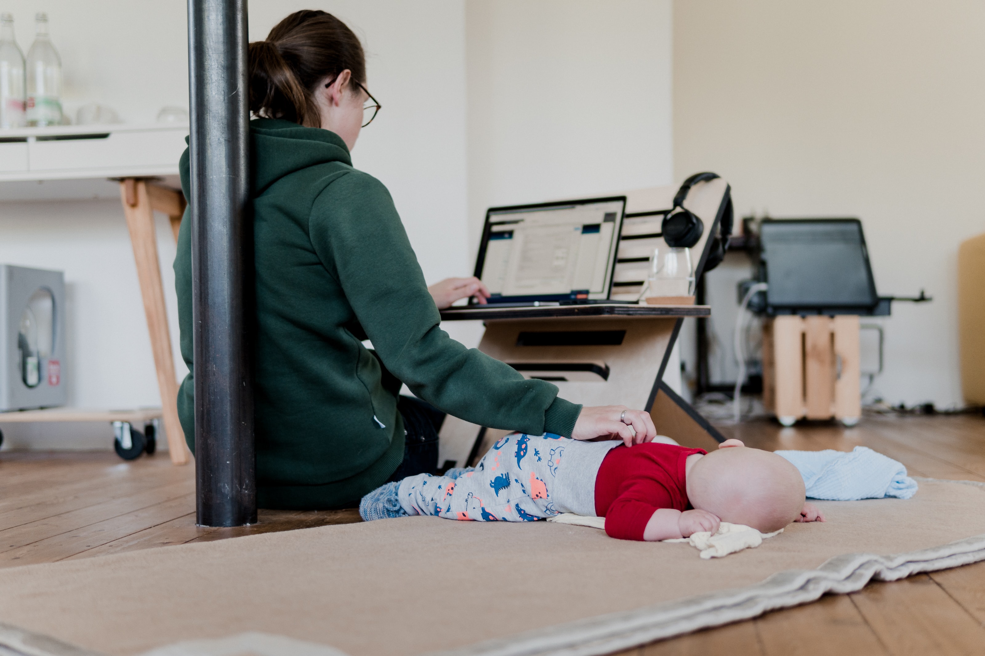 A student doing school work while taking care of her child