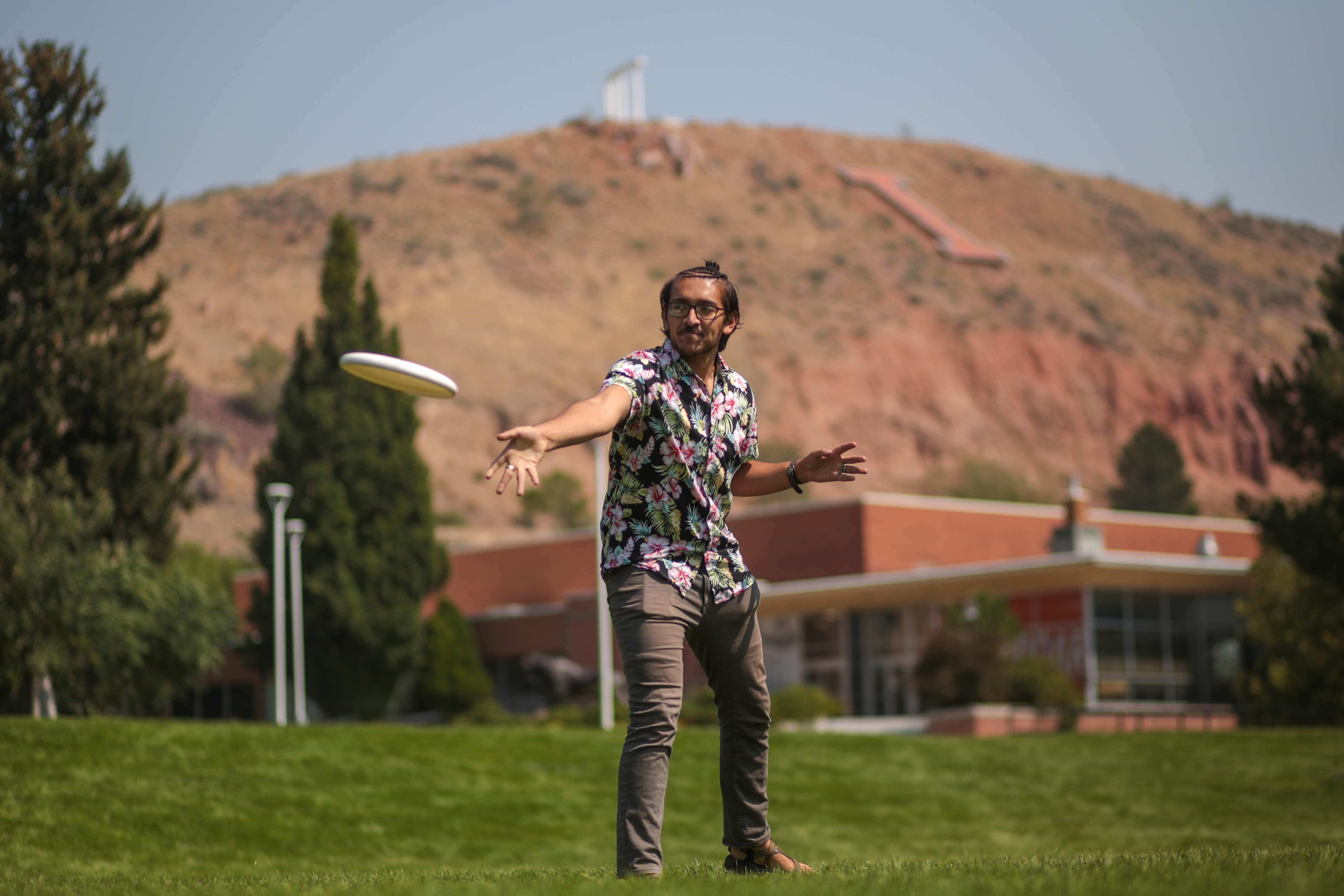 A student on the Quad throwing a frisbee