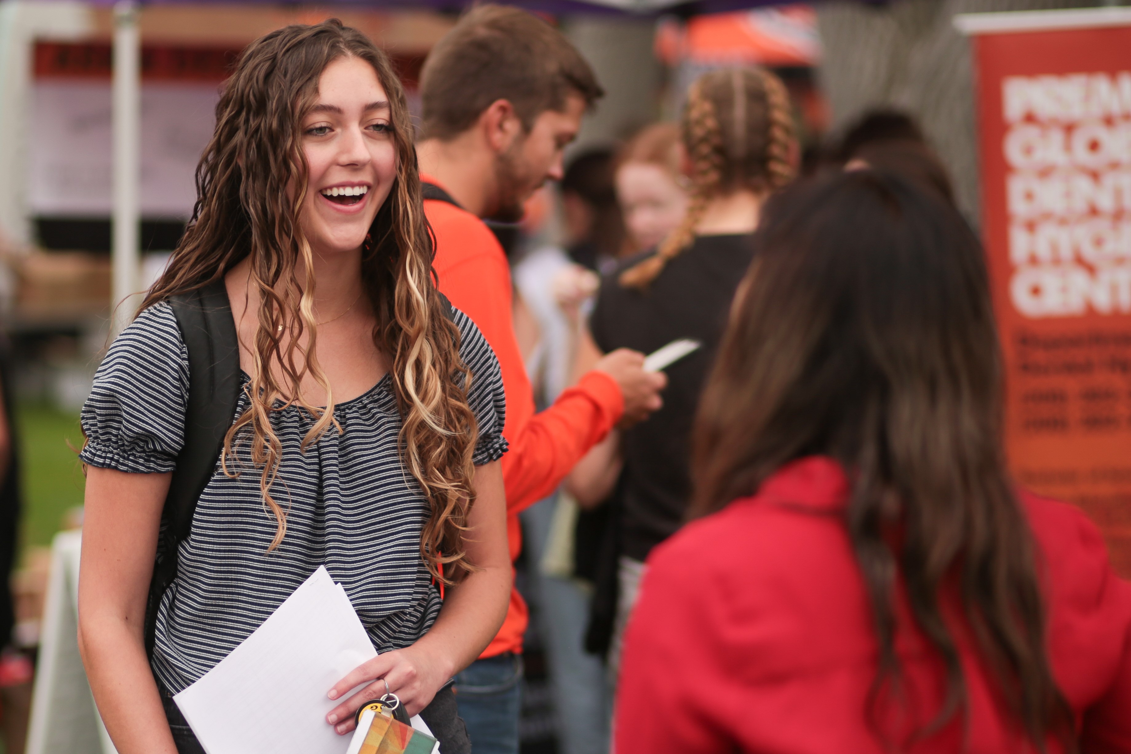 Two female students talking to each other at a student involvement fair.