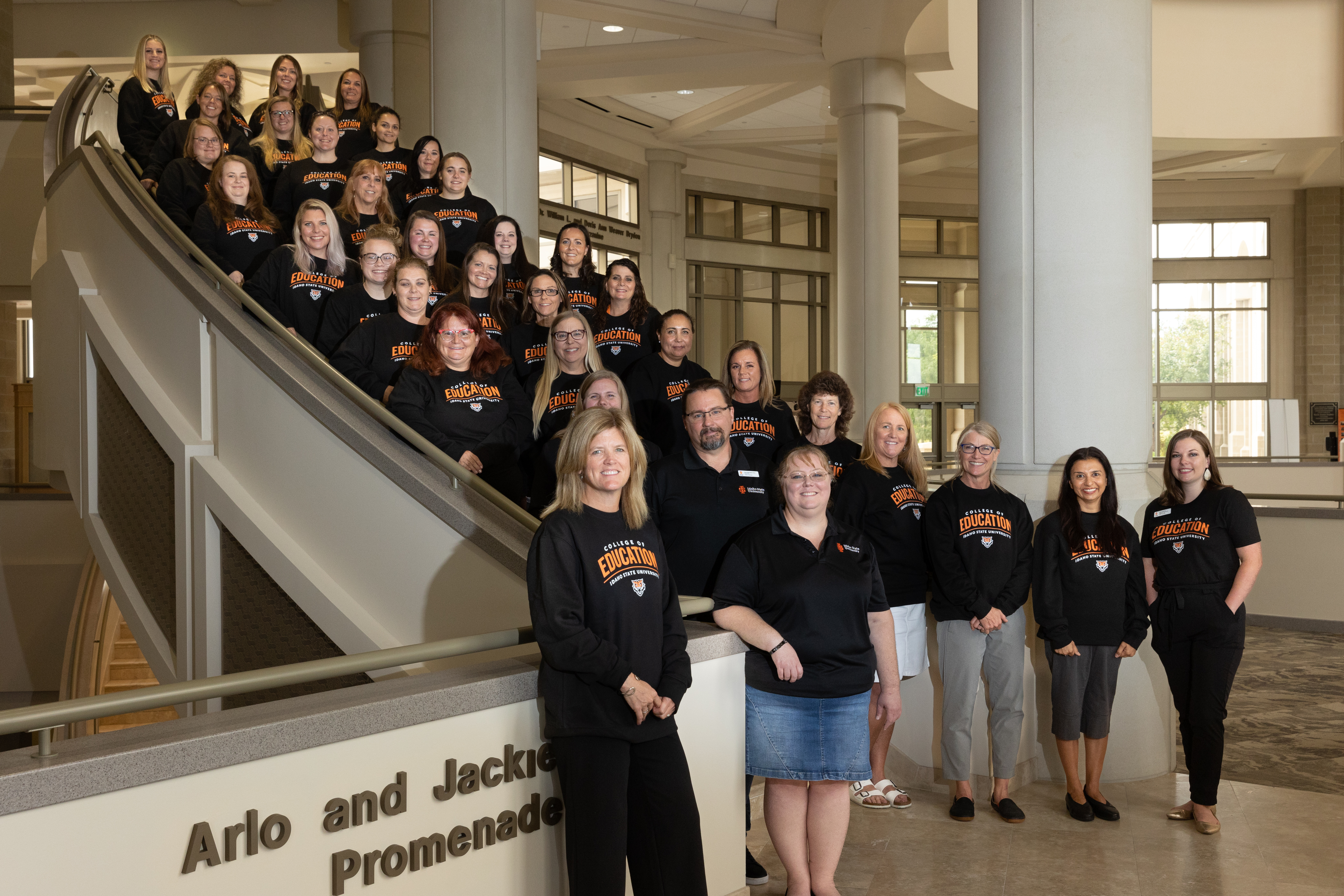 Paraprofessional to Certified Teacher Program (PaCT) students, advisors, professors and dean on stairwell