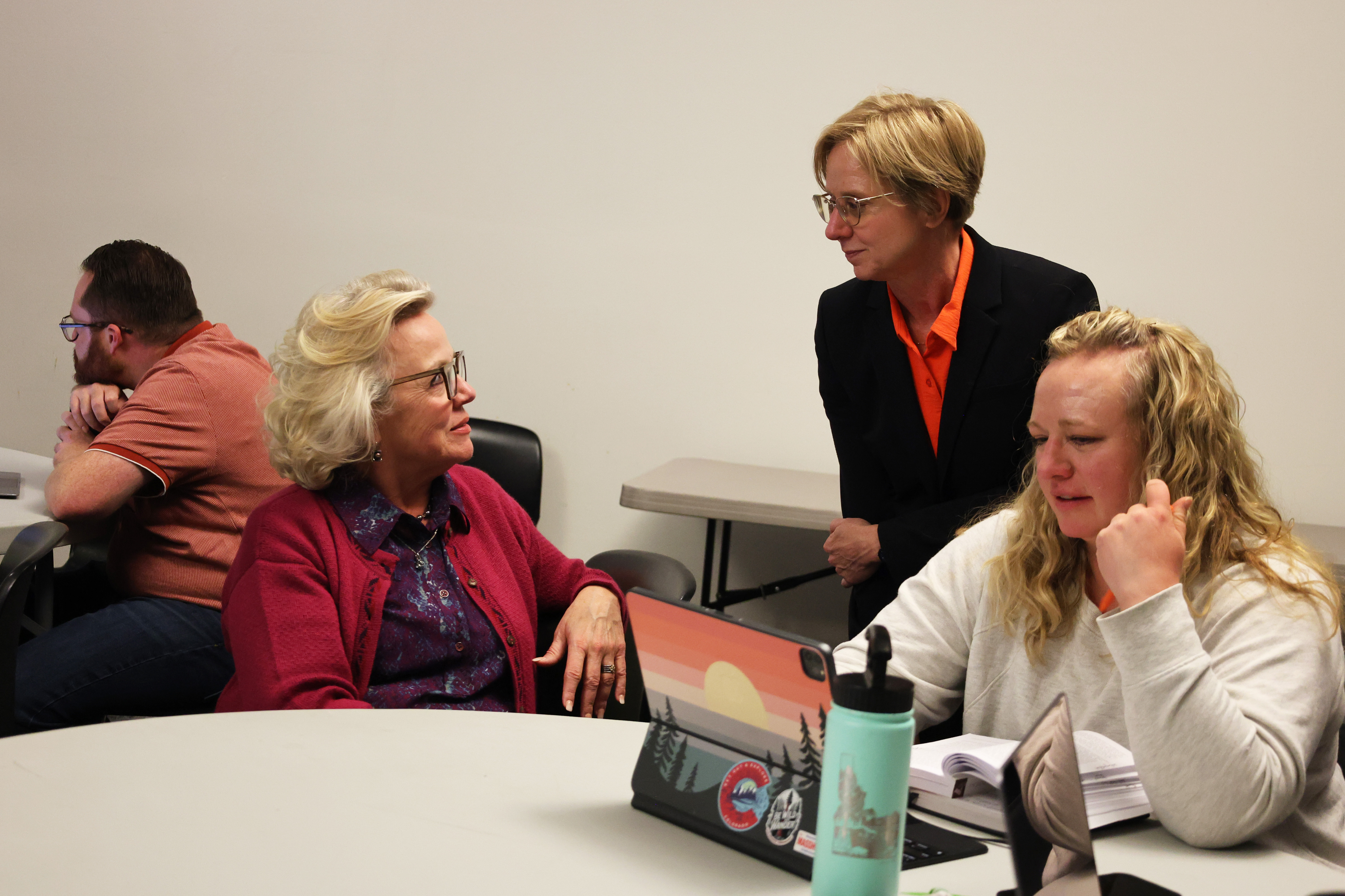 A keynote speaker visiting with guests during a workshop