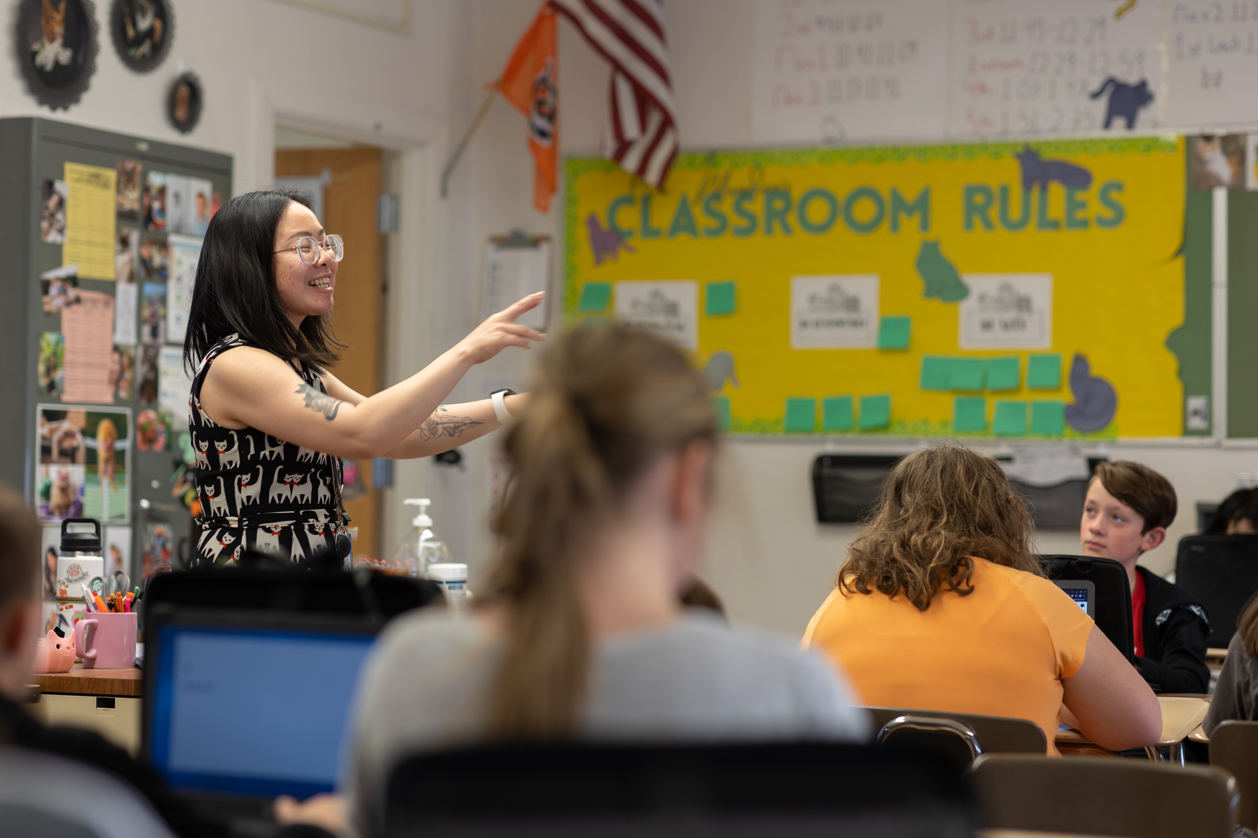 A teacher instructs middle school students in classroom.