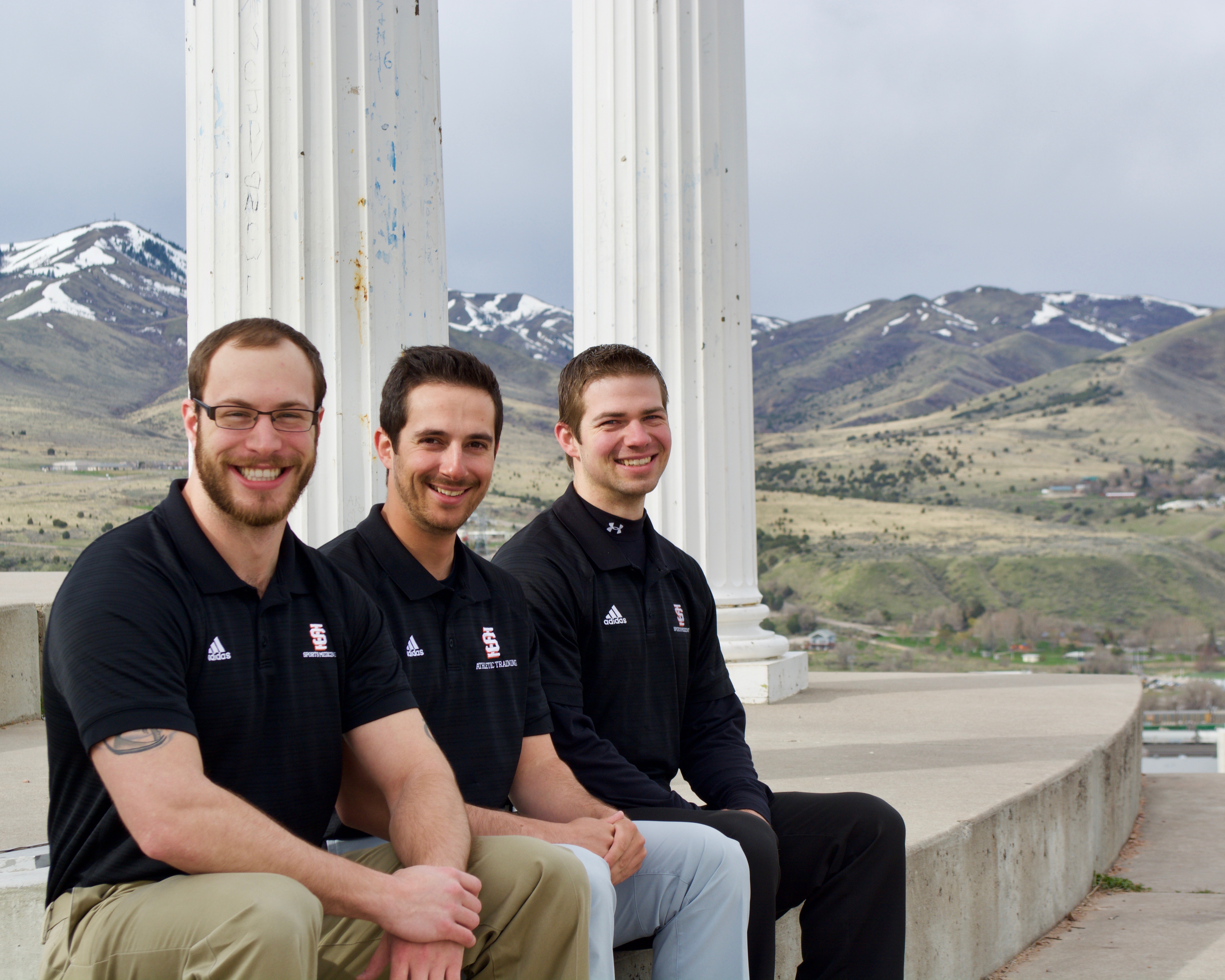 Students sitting at columns on campus