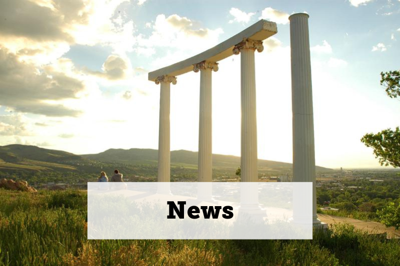 ISU pillars in foreground with sun lit clouds in background. Text: News. Links to news page