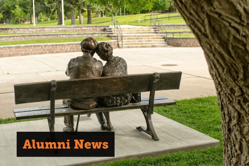 A statue of an old couple sitting together on a bench. Text reads: Alumni News.