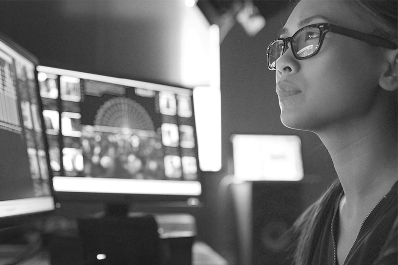 Female looking at computer screens in control room