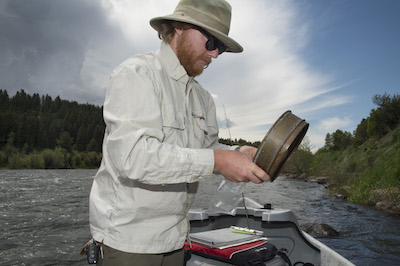 05-29-18 Adam Eckersell studying salmonflies; Henry's River. Photo by Eric Gordon, University Photographer.